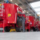 produksjon av foringsblandere. fire maskiner på rekke hvor tre personer skruer på maskinene